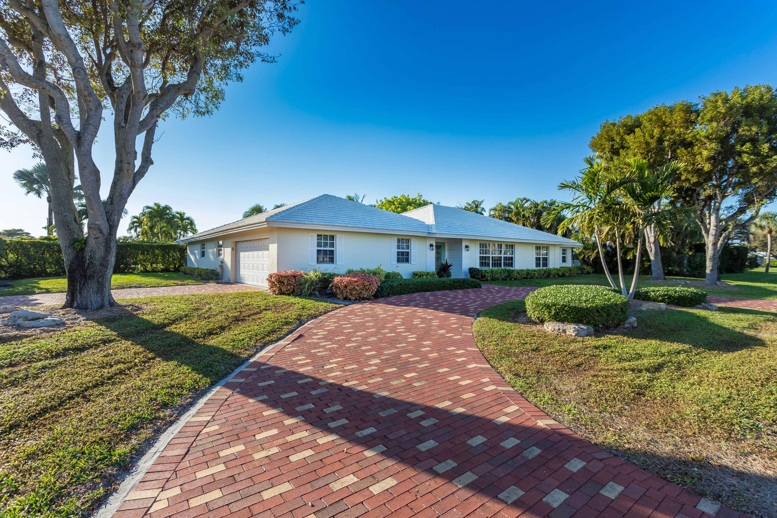 Newly renovated sprawling ranch style home with circular driveway and 2 car garage on corner lot.