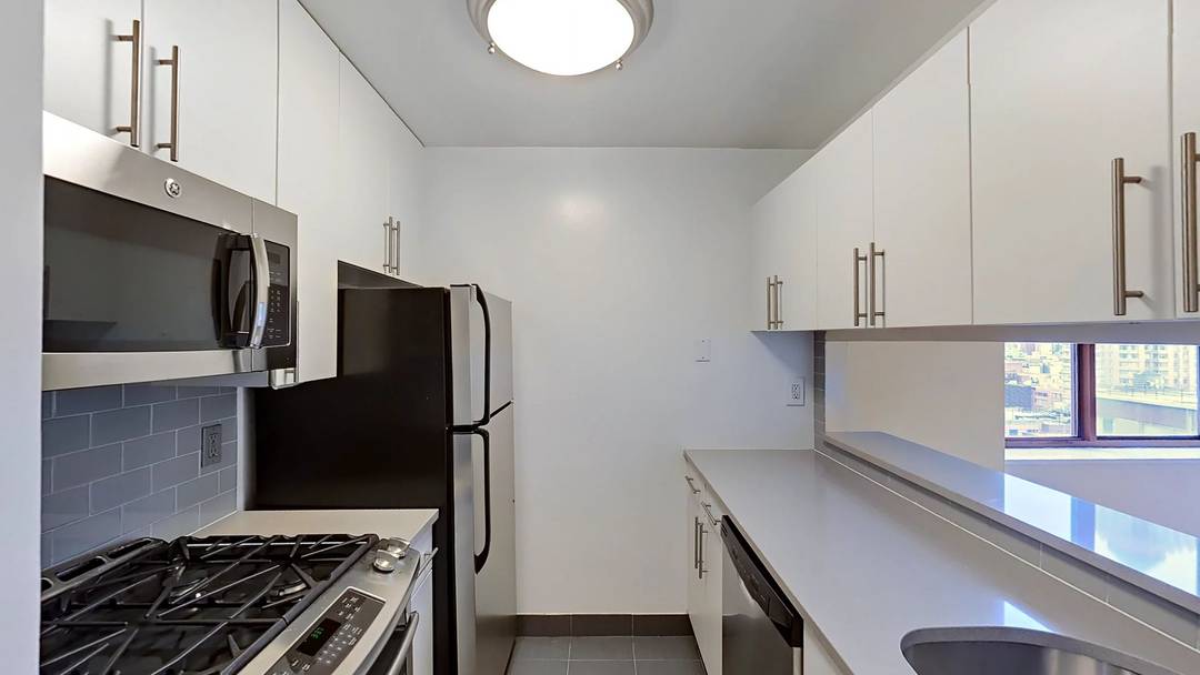 Cozy studio with double exposures, two walk in closets, contemporary kitchen with stainless steel appliances and stone countertops, and wood floors throughout.