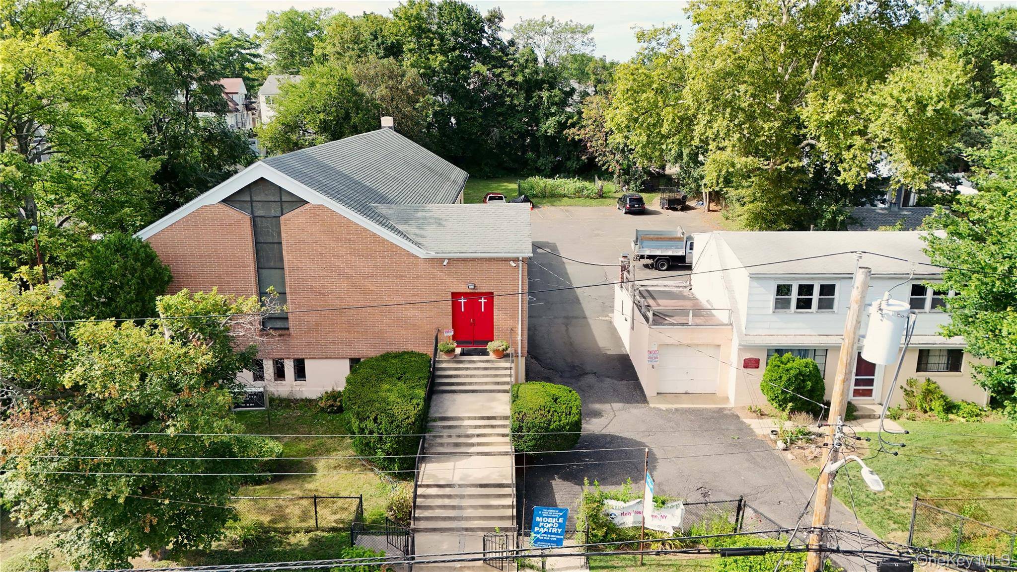 3, 000 sf Worship Space with Fellowship Hall, separate Parish House and large parking lot in central New Rochelle a short walk from Iona University.