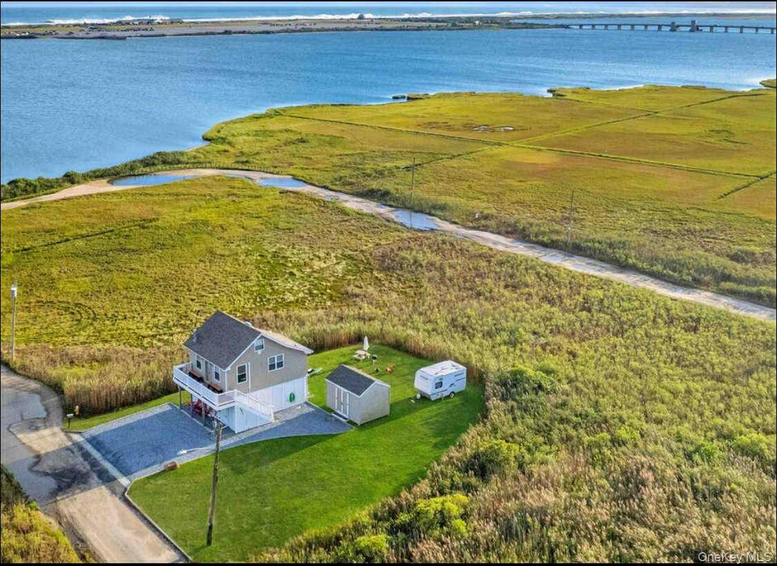 Enjoy sweeping bay views from this elevated and energy efficient 1 bedroom, 1 bath home in Mastic Beach.