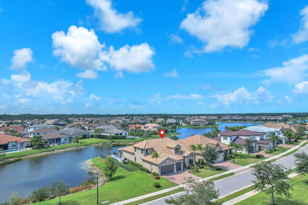Exclusive waterfront gem on a rare ultra premium corner lot in Sonoma Isles, Jupiter, Florida where panoramic lake views captivate from every angle.