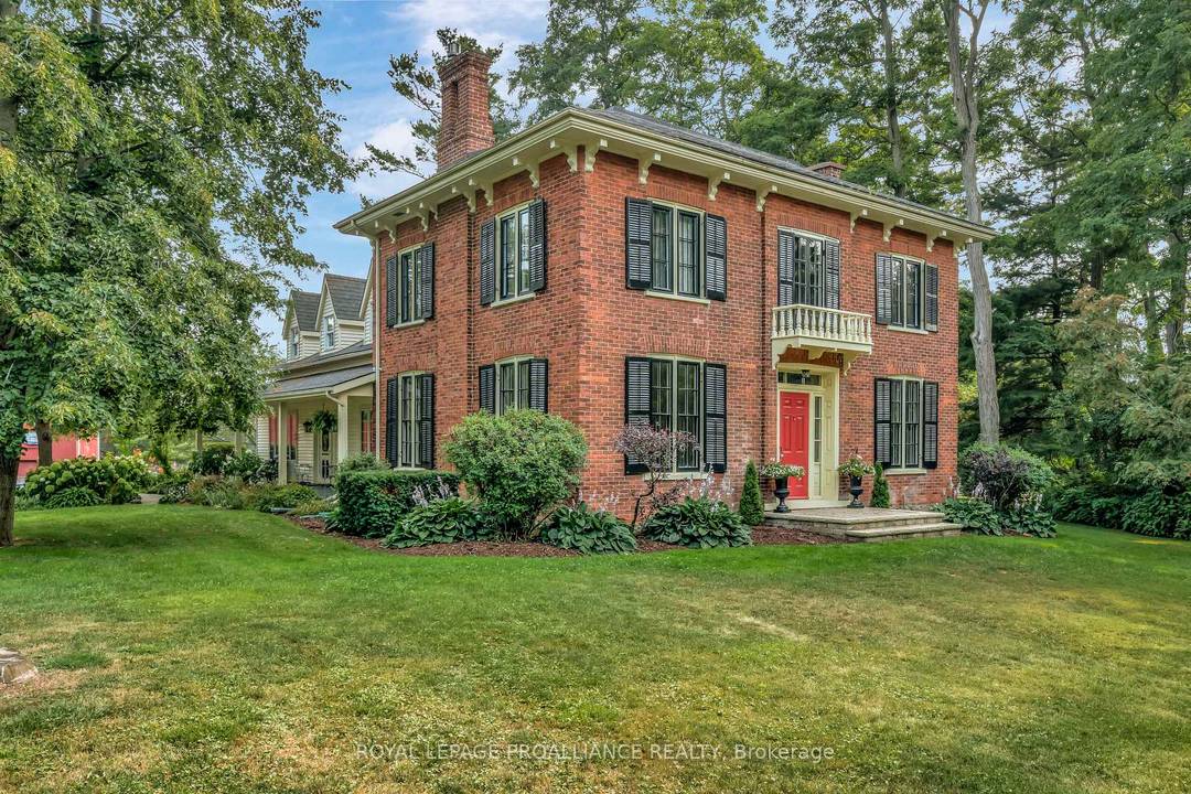 Welcome to this beloved county gem, a century old red brick home located just on the edge of Bloomfield, elegantly set back from Loyalist Parkway in a grove of conifers.