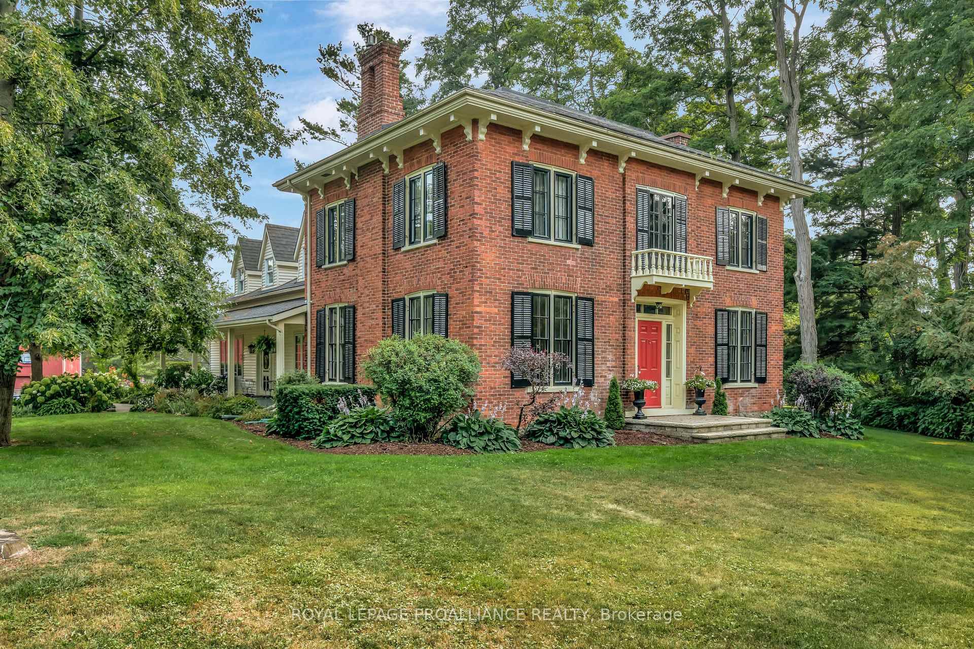 Welcome to this beloved county gem, a century old red brick home located just on the edge of Bloomfield, elegantly set back from Loyalist Parkway in a grove of conifers.