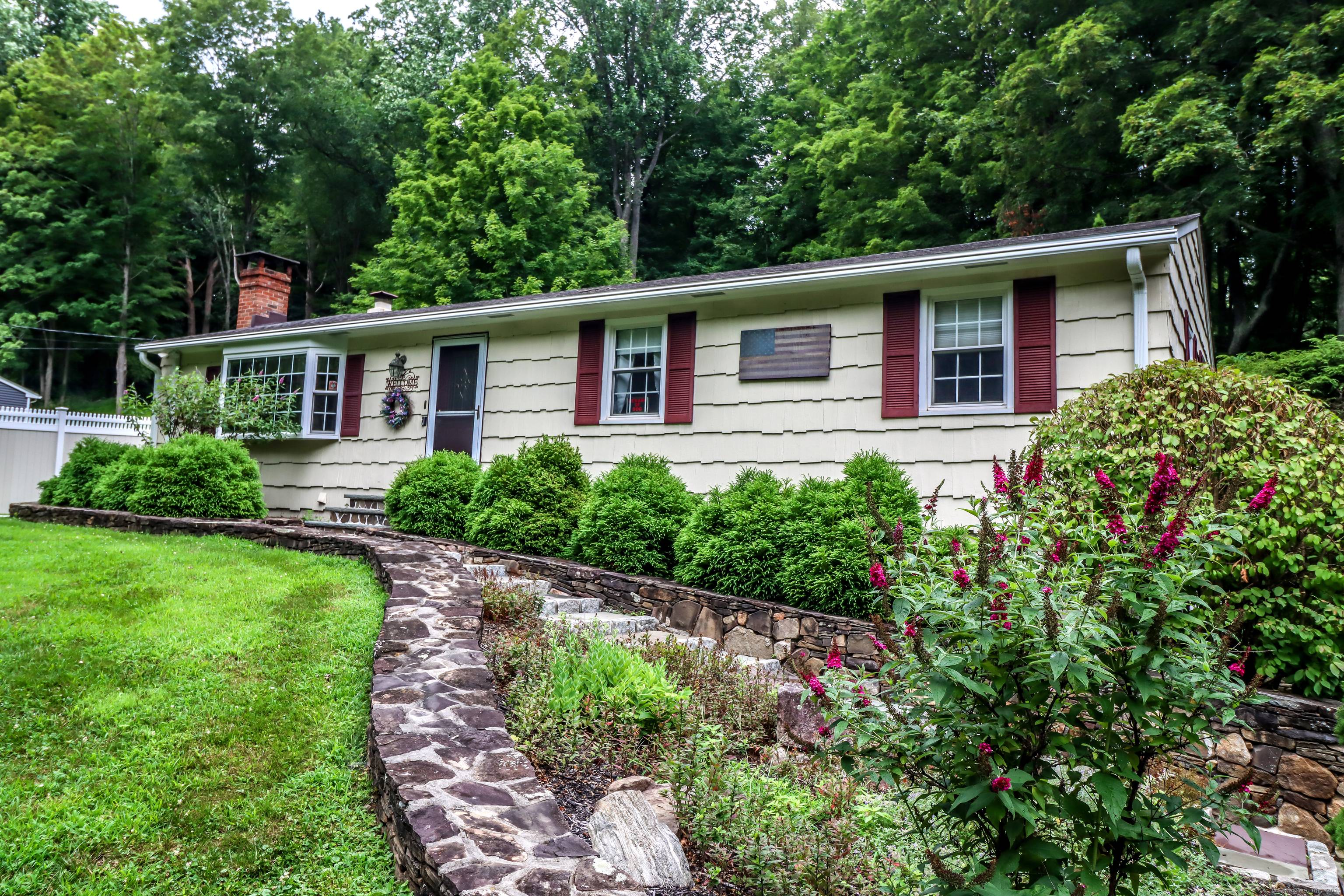Tucked against a backdrop of lush woods, this appealing Ranch is the perfect blend of comfort natural beauty.