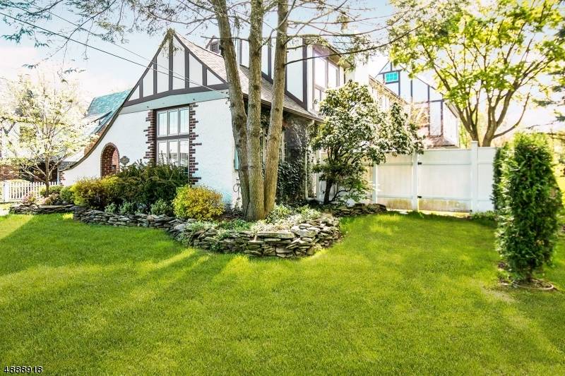 Cool neutrals and timeless design elevate this beautifully renovated Cotswold Tudor, nestled on a lush and private.