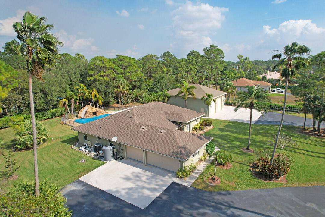 Set on a private, lush acreage near West Palm Beach, this property delivers true Florida lifestyle living.