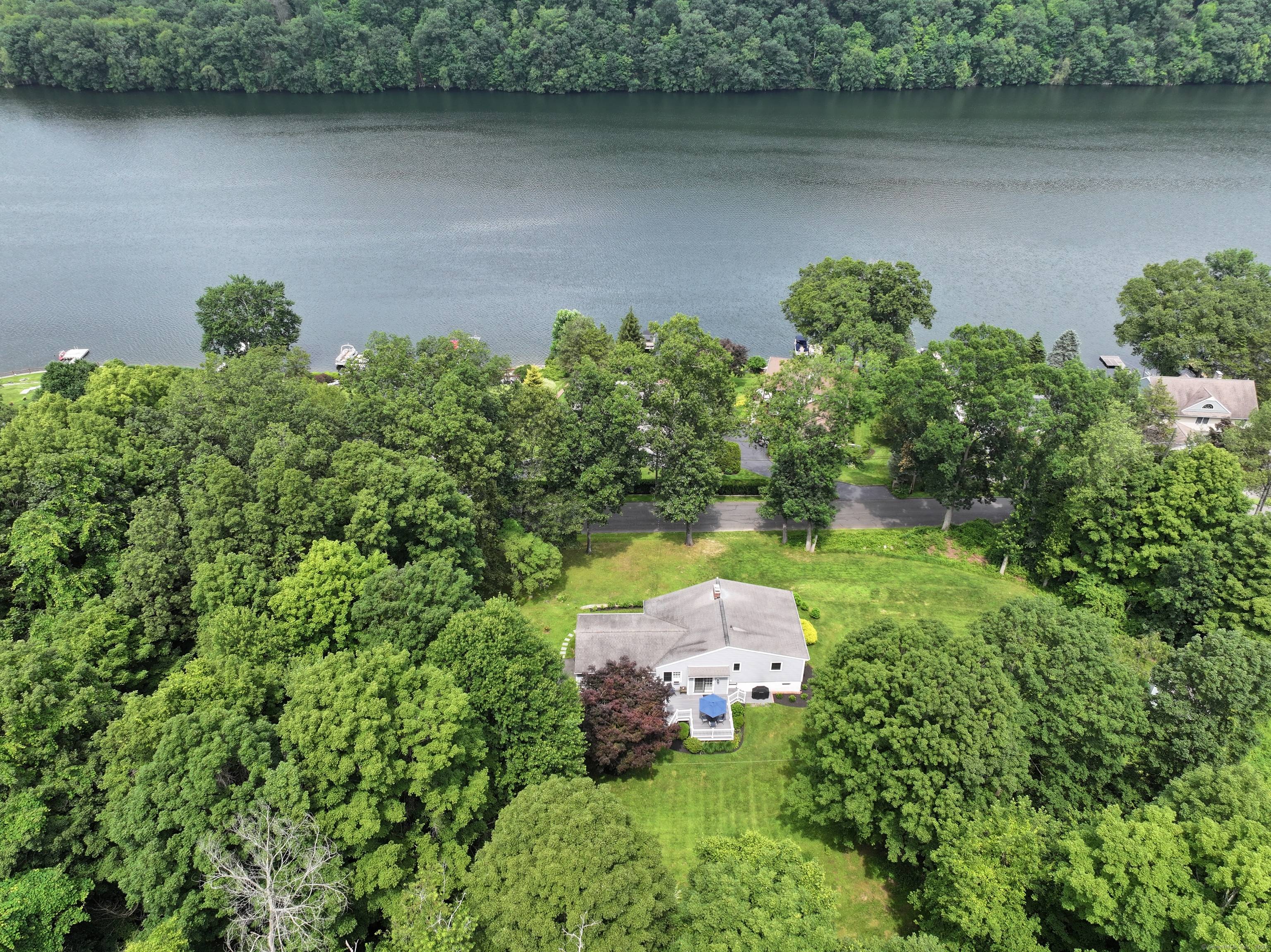 Savor spectacular views of Lake Lillinonah from this classic split level home set on over 2 acres of park like grounds.