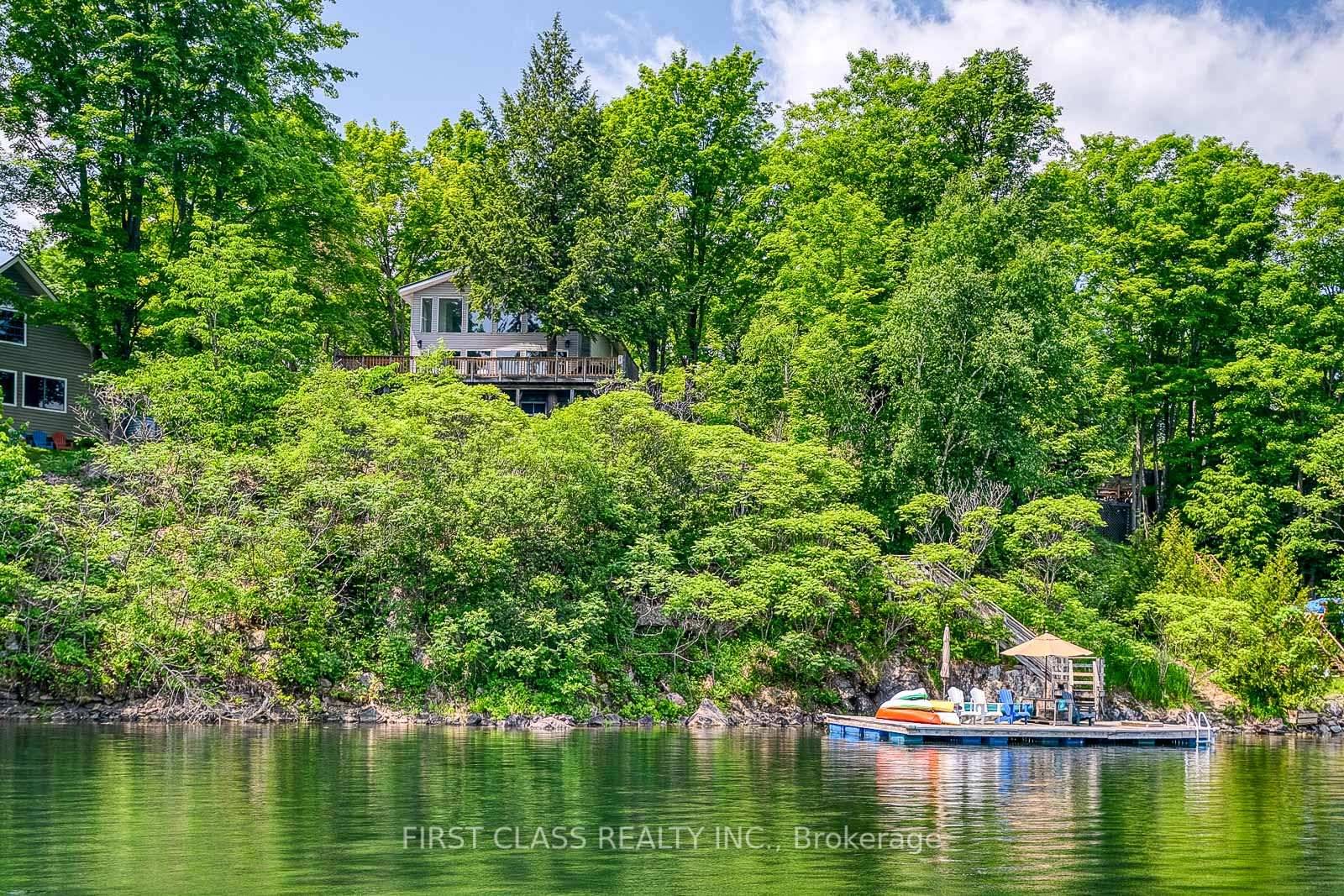 Stunning year round lakefront retreat on Thirty Island Lake with 160 ft of private shoreline, sandy beach, and panoramic south facing views.