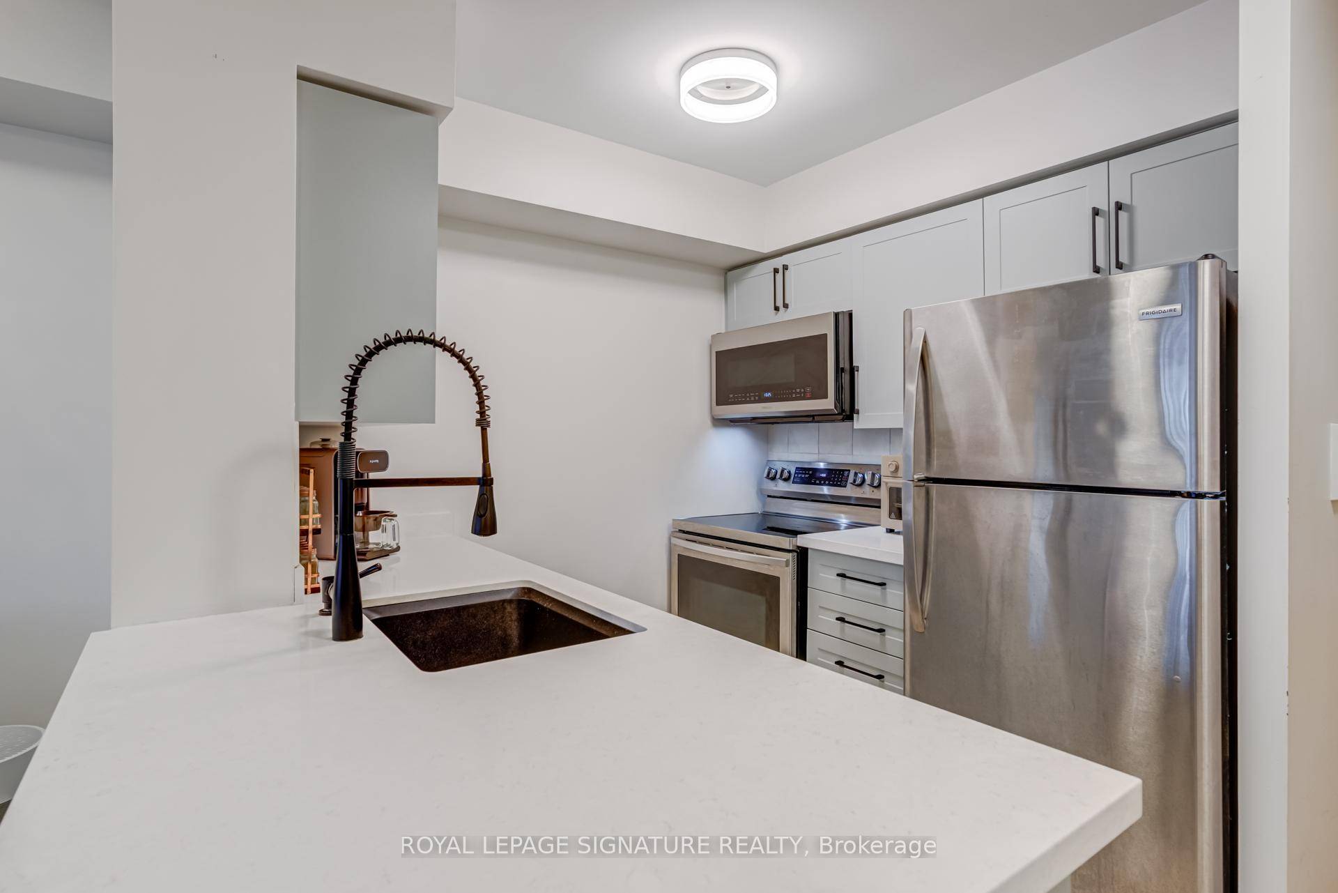 Renovated in 2021. A pretty blue gray kitchen you'll want to cook in with new cabinetry, chunky quartz counters, granite sink, updated hardware, faucet and plumbing.