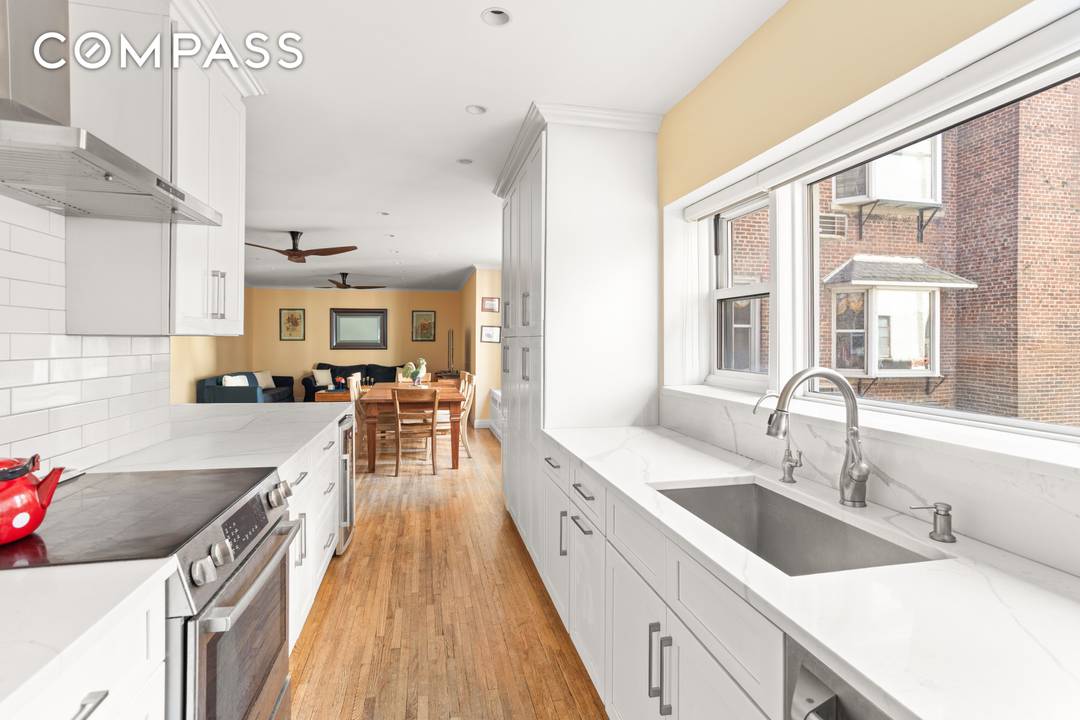 Enter this lovely home and immediately be greeted by beautiful prewar details, including an expansive custom wooden built in bookcase, moldings, oak hardwood flooring, and more.