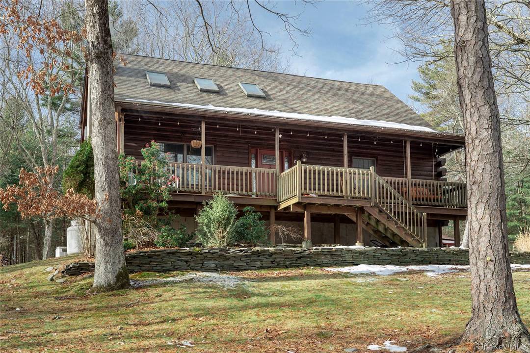 Perched atop a scenic country road, this bright and welcoming log cabin retreat rests on 5 wooded acres, full of classic Catskills charm.