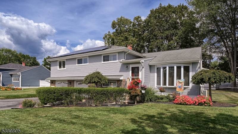 Welcome to this beautifully expanded split level home nestled on a picturesque, tree lined street that feels like a storybook setting.