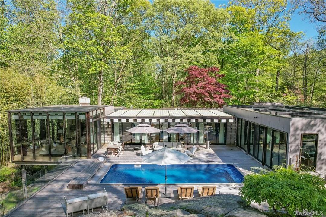 Introducing this stunning mid century modern retreat, nestled in the serene woods in Scarsdale's Quaker Ridge School District.