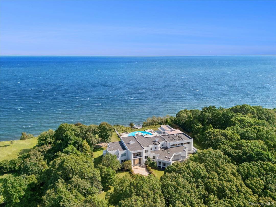Secluded on over 8 acres of elevated land within the prestigious enclave of Belle Terre, this sprawling waterfront estate offers unmatched privacy and commanding views across the Long Island Sound.