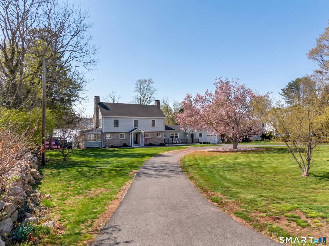 Timeless charm defines this classic New England Colonial, beautifully set on 1.
