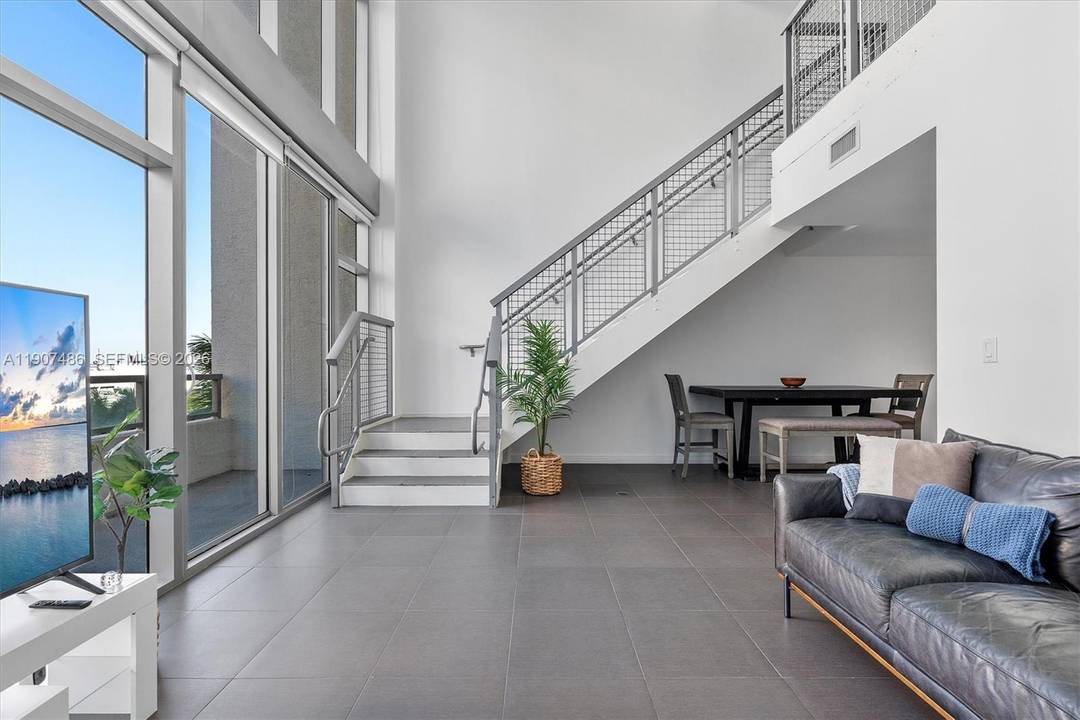 Welcome to Unit M0502 at Four Midtown Condo a true loft living experience with soaring 30 foot ceilings and expansive windows that bathe the space in natural light.