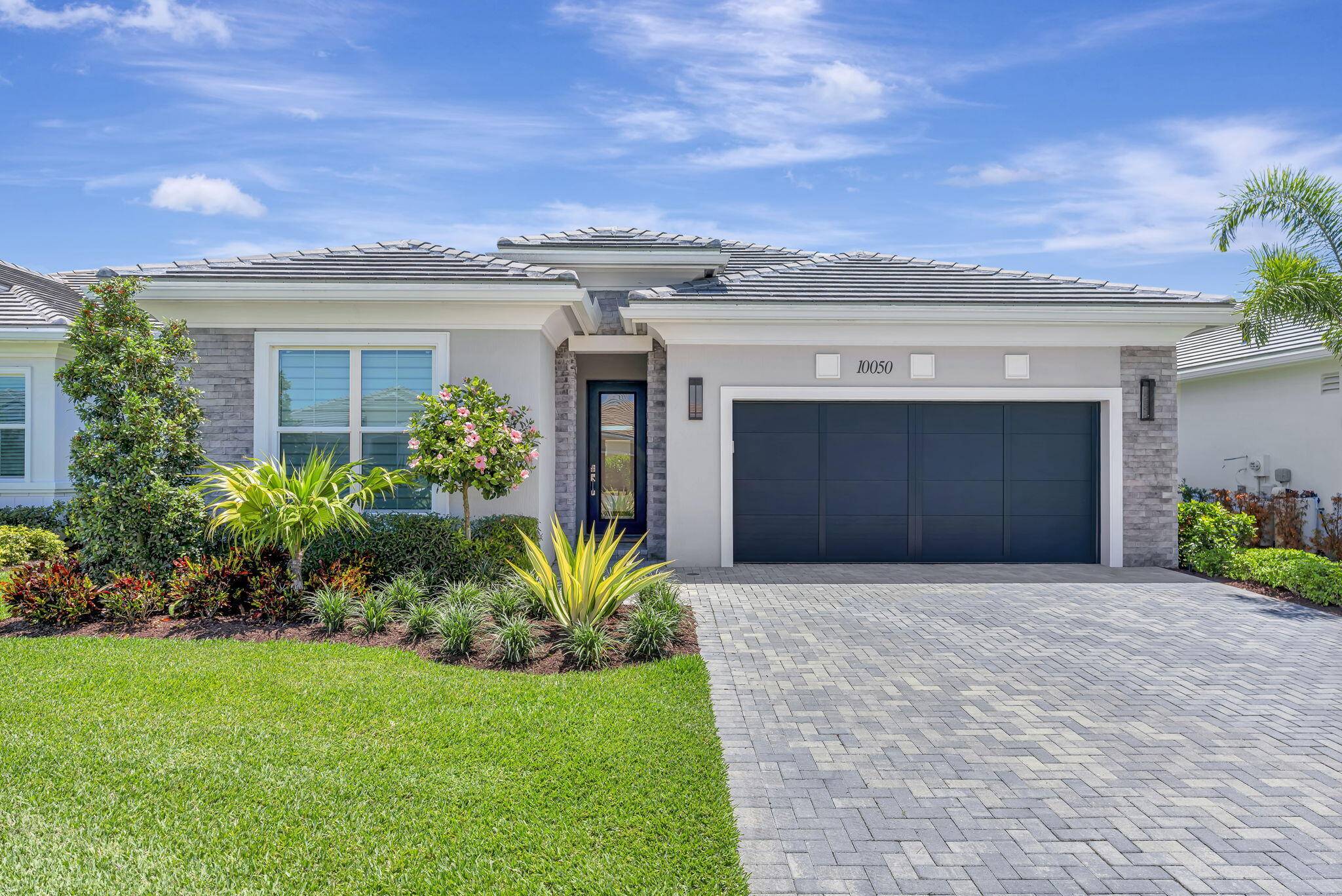 This McKenna is a beautiful home with a Contemporary elevation with a veneer stone exterior.