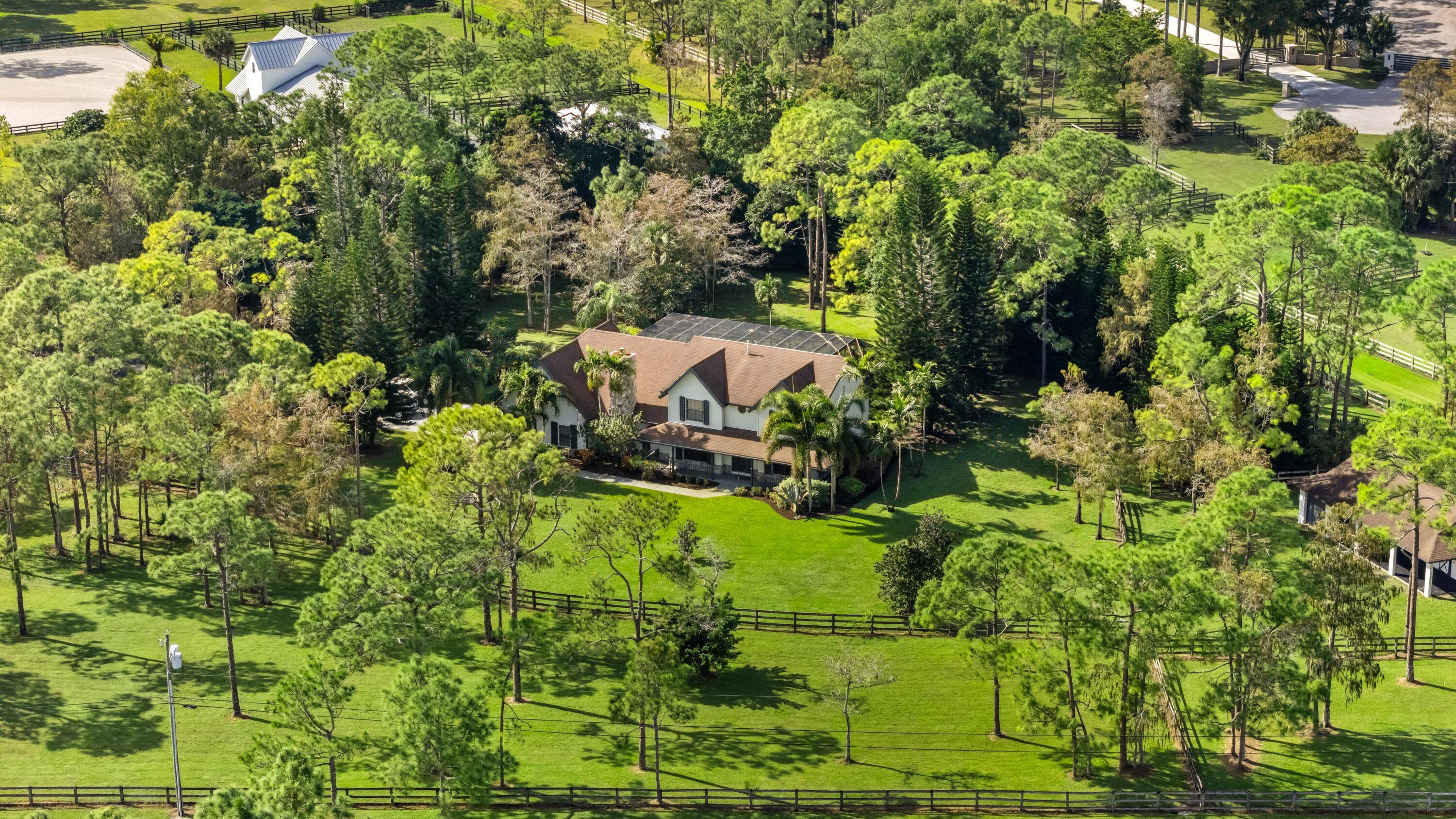 Set on 5 acres in the prestigious, gated equestrian community of Homeland, this Northern style Colonial blends timeless charm with modern comforts.