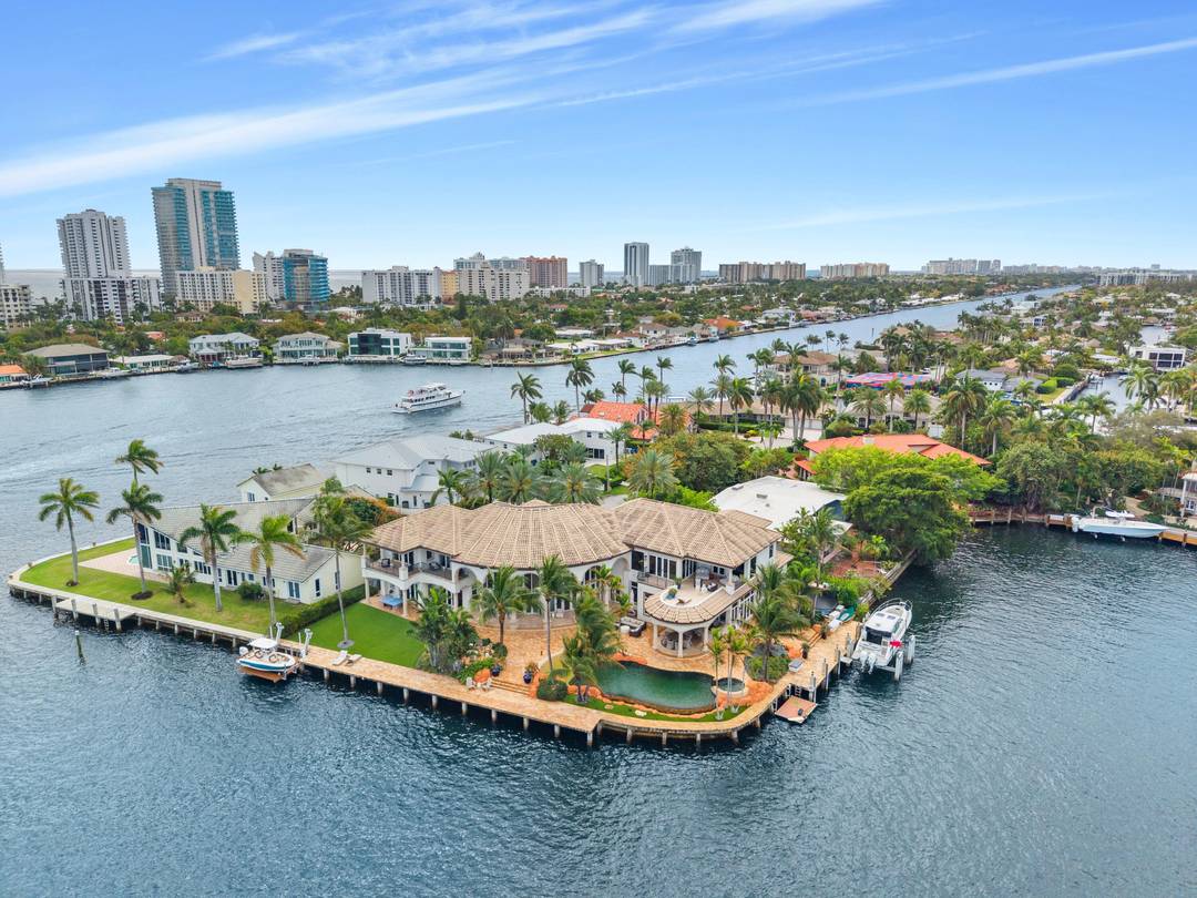 Set on a coveted point lot where the Intracoastal meets Lake Santa Barbara, this exceptional waterfront estate offers over 270 feet of prime dockage, accommodating multiple large vessels with ease.