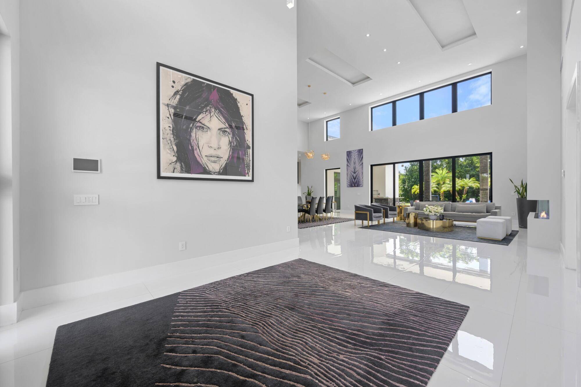Modern masterpiece on expansive grounds, boasting soaring 20 ft ceilings, sleek porcelain floors, and a chef's kitchen with custom cabinetry and quartz counters.