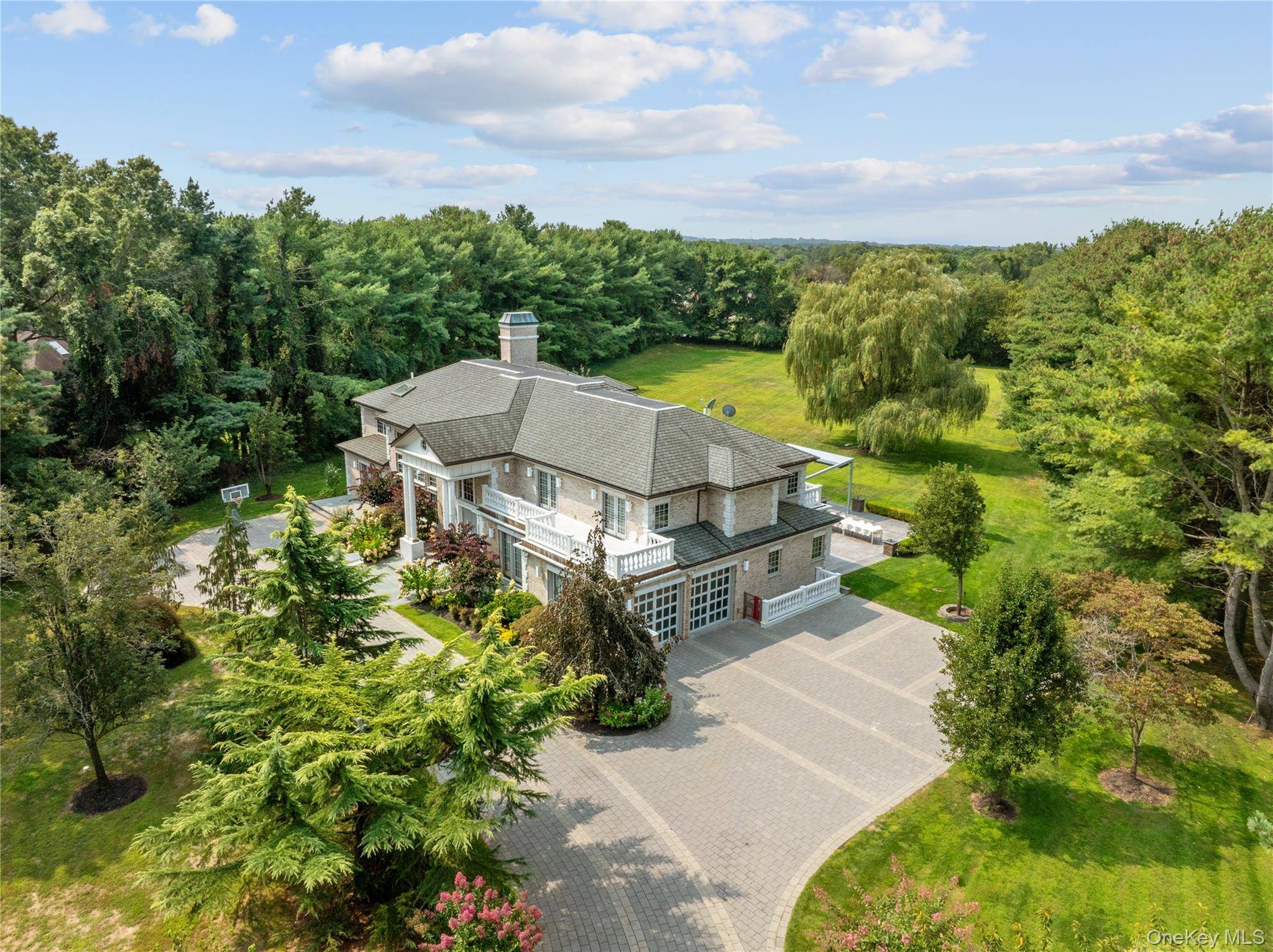 This gorgeous Brick Colonial, located in Upper Brookville, is a beautiful and elegant estate that sits on 2.