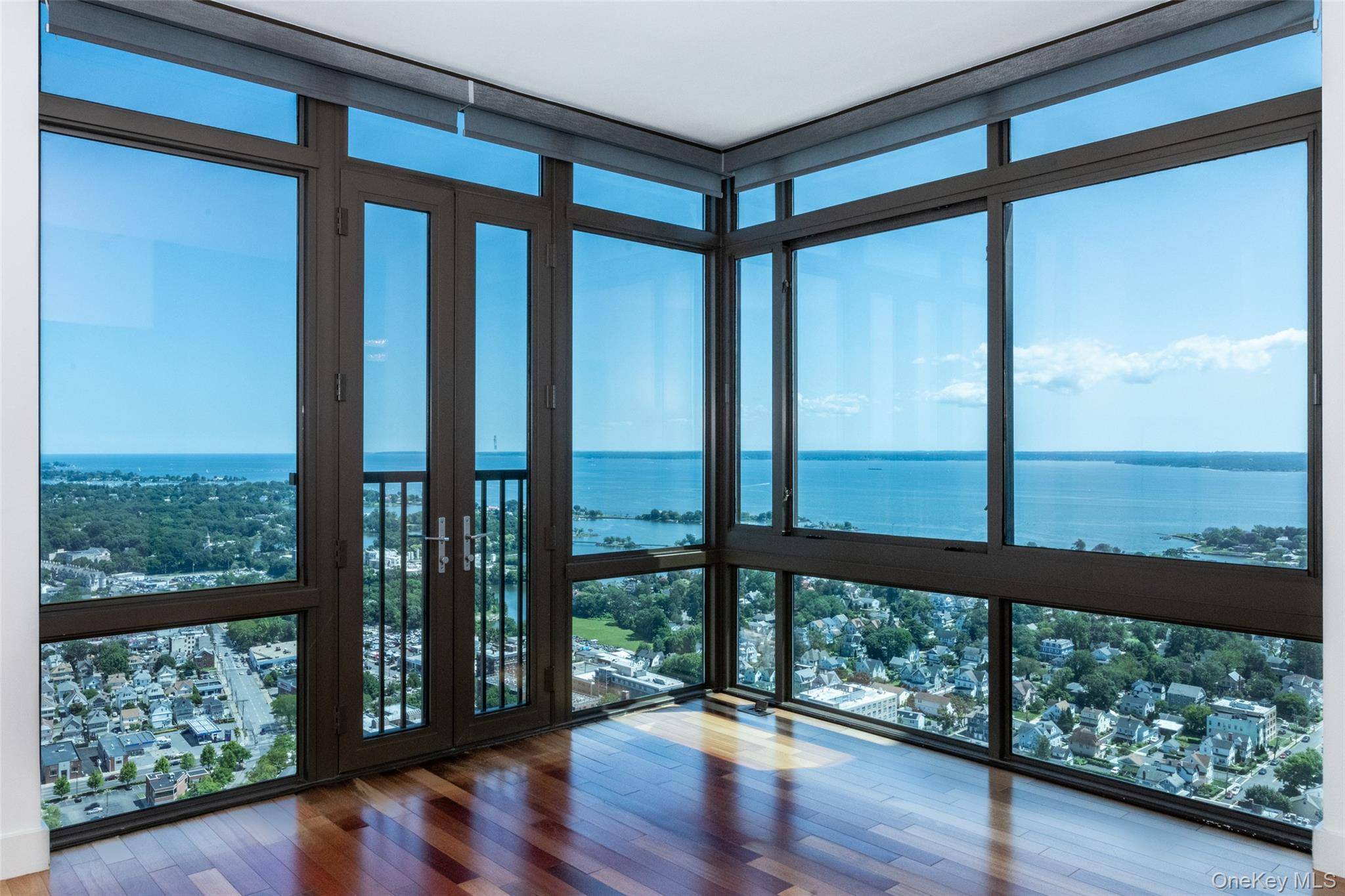 Perched high above the city, this exceptional three bedroom corner residence offers panoramic views of the Long Island Sound and an unparalleled living experience.