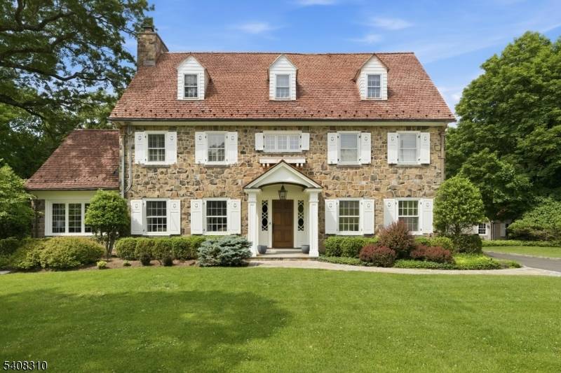 Situated on nearly an acre in Old Short Hills, this timeless fieldstone Colonial offers a rare balance of architectural significance and livability.