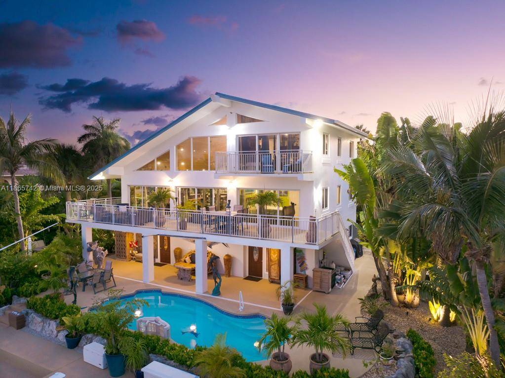 This wonderfully remodeled three story home in exclusive Coco Plum has a spacious open layout with exceptional water views.