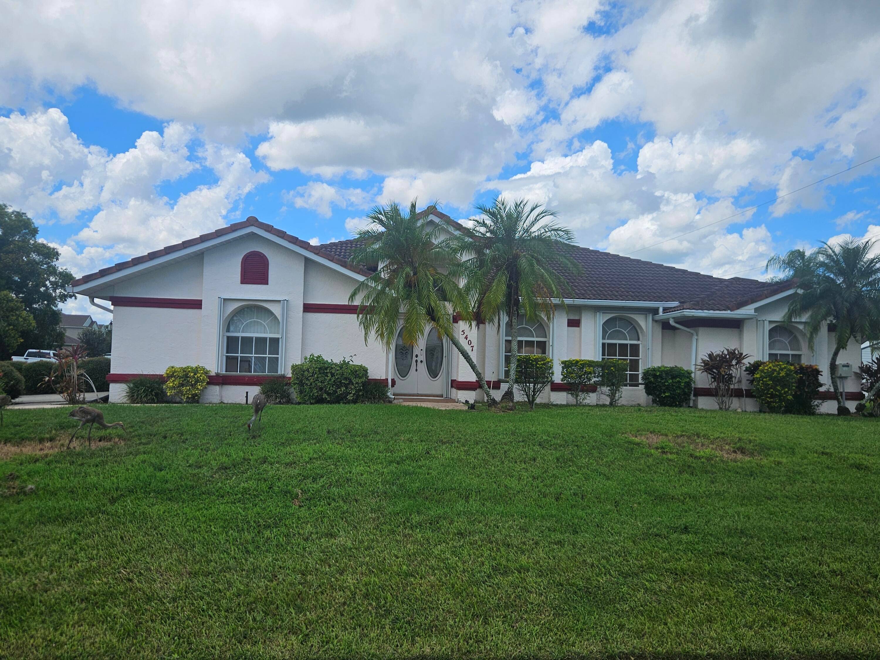 This spacious home is on a sweeping corner lot with a large patio and screened in pool.