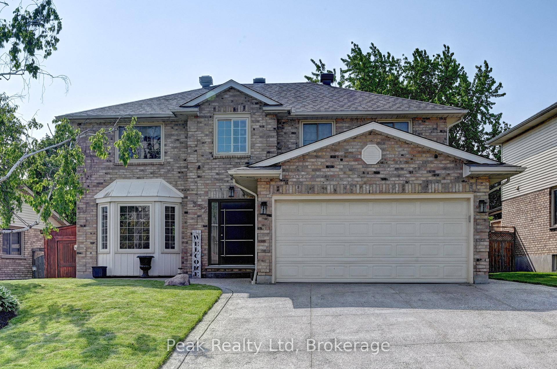 Beautifully updated home offering exceptional curb appeal with a neutral cream brick exterior, modern front door, concrete driveway, and double car garage.