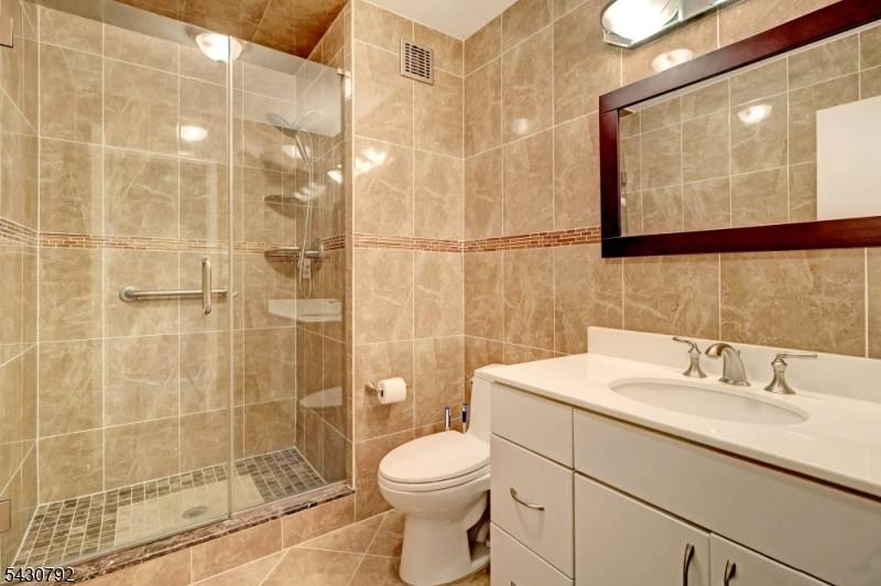 One to see Renovated 2 bed, 2 bath boasts modern upgrades Galley kitchen features rich, dark wood cabinetry, light granite countertops with a matching backsplash.