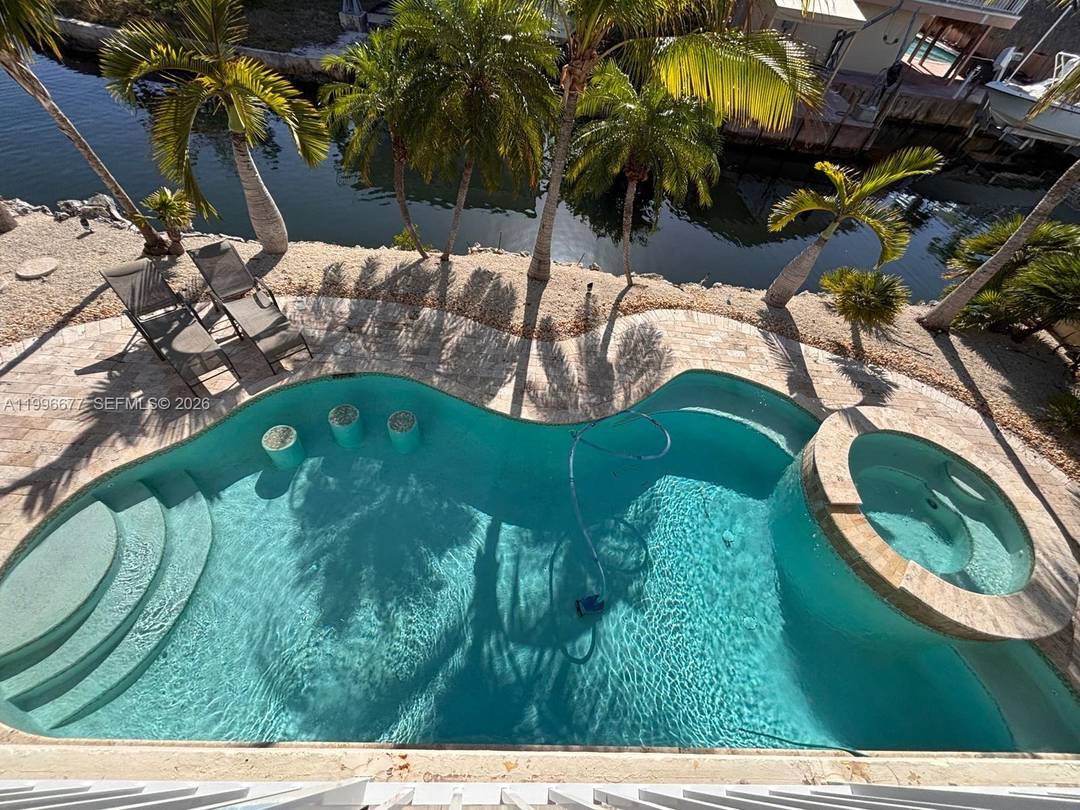 Waterfront oceanside home in Key Largo, Florida on a point lot on a main deep water canal featuring 200 feet 120 feet x 80 feet of water frontage with deep ...