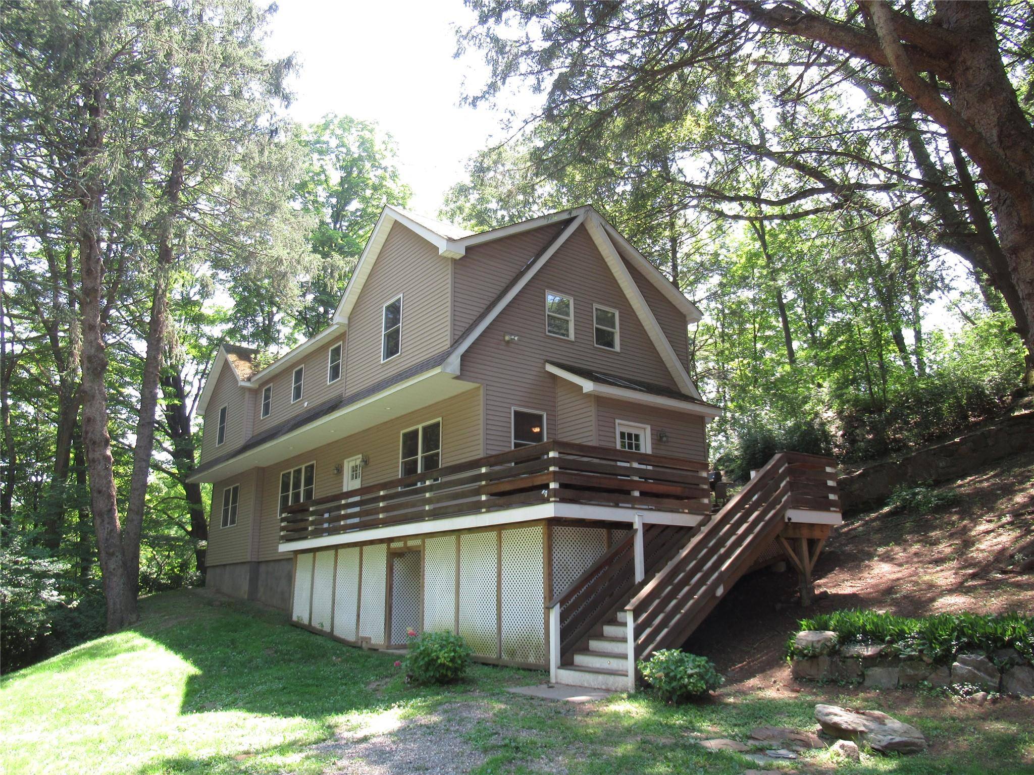 Nestled in between trees and rocks, privacy abounds in this Contemporary Colonial style dwelling with numerous upgrades.