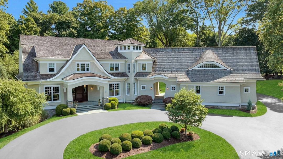 Timeless design meets modern sustainability in this stunning shingle style home, set on 1.