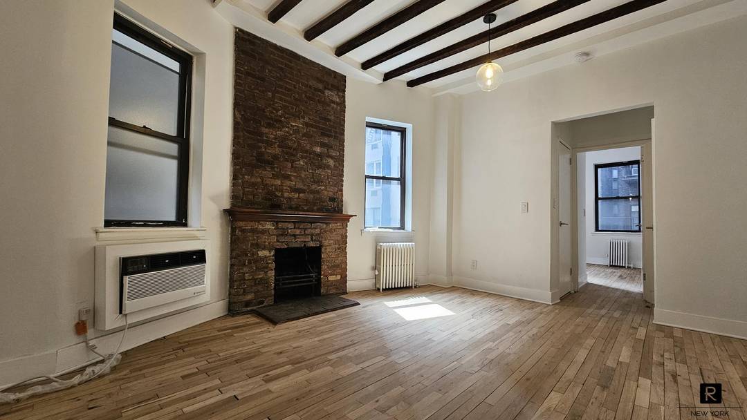 The charming and cozy 1BR 1Bath pre war Co op, 11ft high beamed ceilings with a wood burning fireplace exposed brick.
