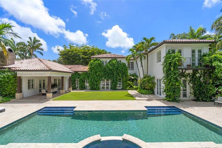 Discover this Mediterranean style retreat on over 1 acre of lush, manicured grounds with a charming courtyard and a small fish pond.