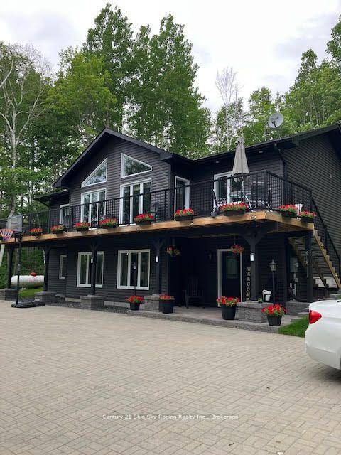 This stunning raised bungalow with front balcony the length of the home, nestled amongst the trees on 2.