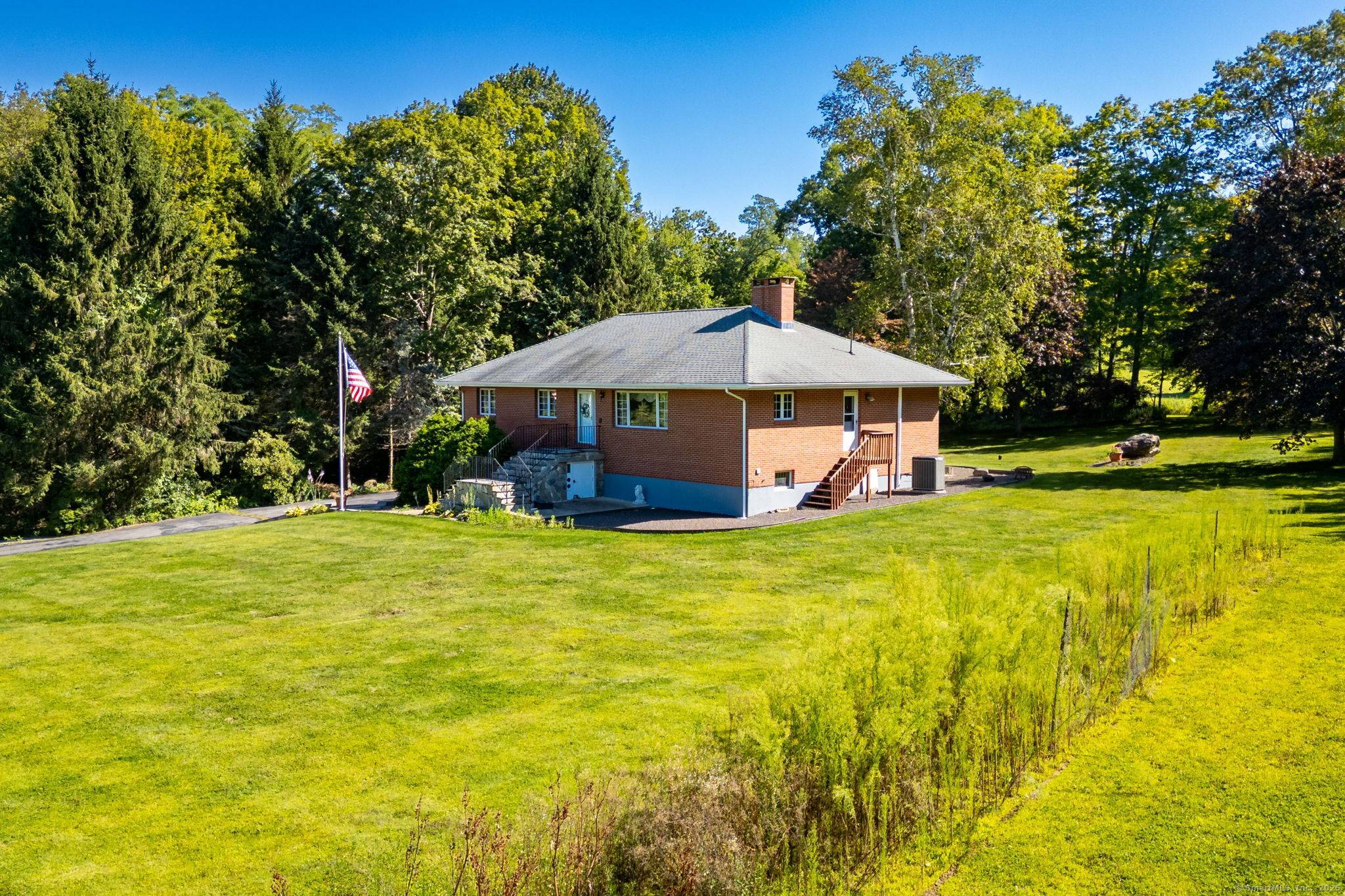 Experience peaceful country living in this charming brick ranch, perfectly positioned on a quiet road amidst beautifully landscaped grounds.
