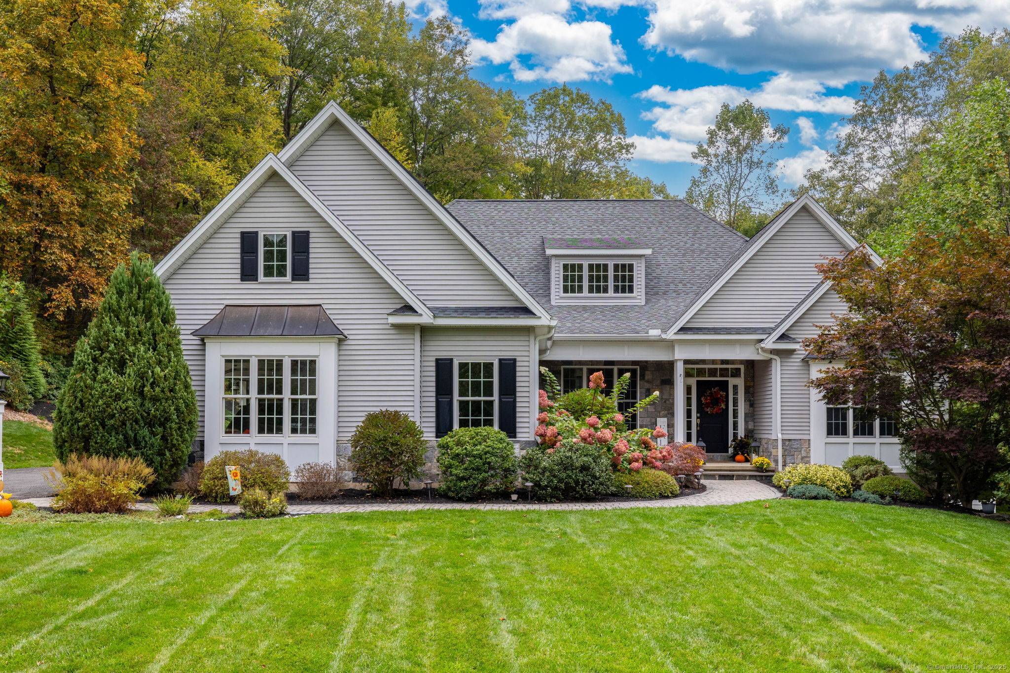 Welcome Home. Discover this beautifully designed Frank Betz residence, thoughtfully customized with a natural stone veneer facade and nestled amid serene, landscaped grounds.