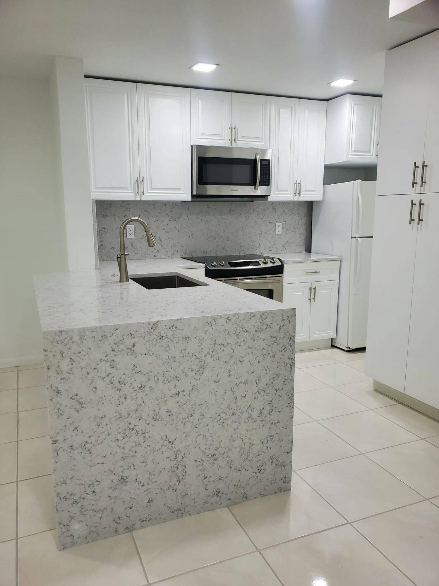 NEW AC, NEW APLIANCES. gorgeous apartment and totally remodeled ground floor unit, kitchen and bathrooms redone, stainless steel appliances and quartz countertops.