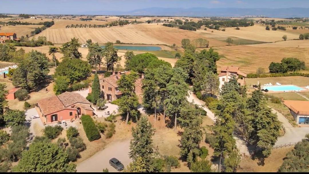 Holiday farm with two country houses and two swimming pools for sale near Castiglione del Lago, Umbria. Hill top position and private plots.