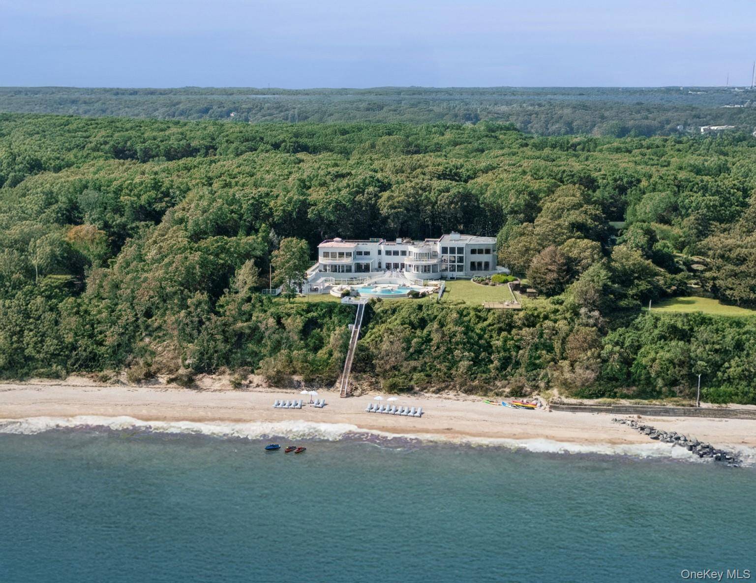 Tucked away on over 8 acres of elevated land in the exclusive Belle Terre enclave, this sprawling waterfront estate offers rare privacy and sweeping vistas of the Long Island Sound.