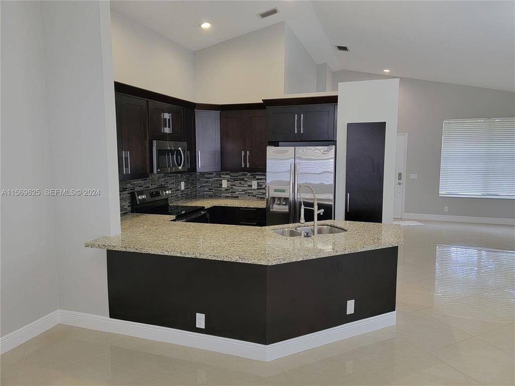 BEAUTIFUL PROPERTY ALERT GORGEOUS OPEN CONCEPT KITCHEN W GRANITE COUNTER TOP, STAINLESS STEEL APPLIANCES, PORCELAIN TILE, UPGRADED BATHROOMS, 2 CAR GARAGE, A C 2018 and accordion shutters.