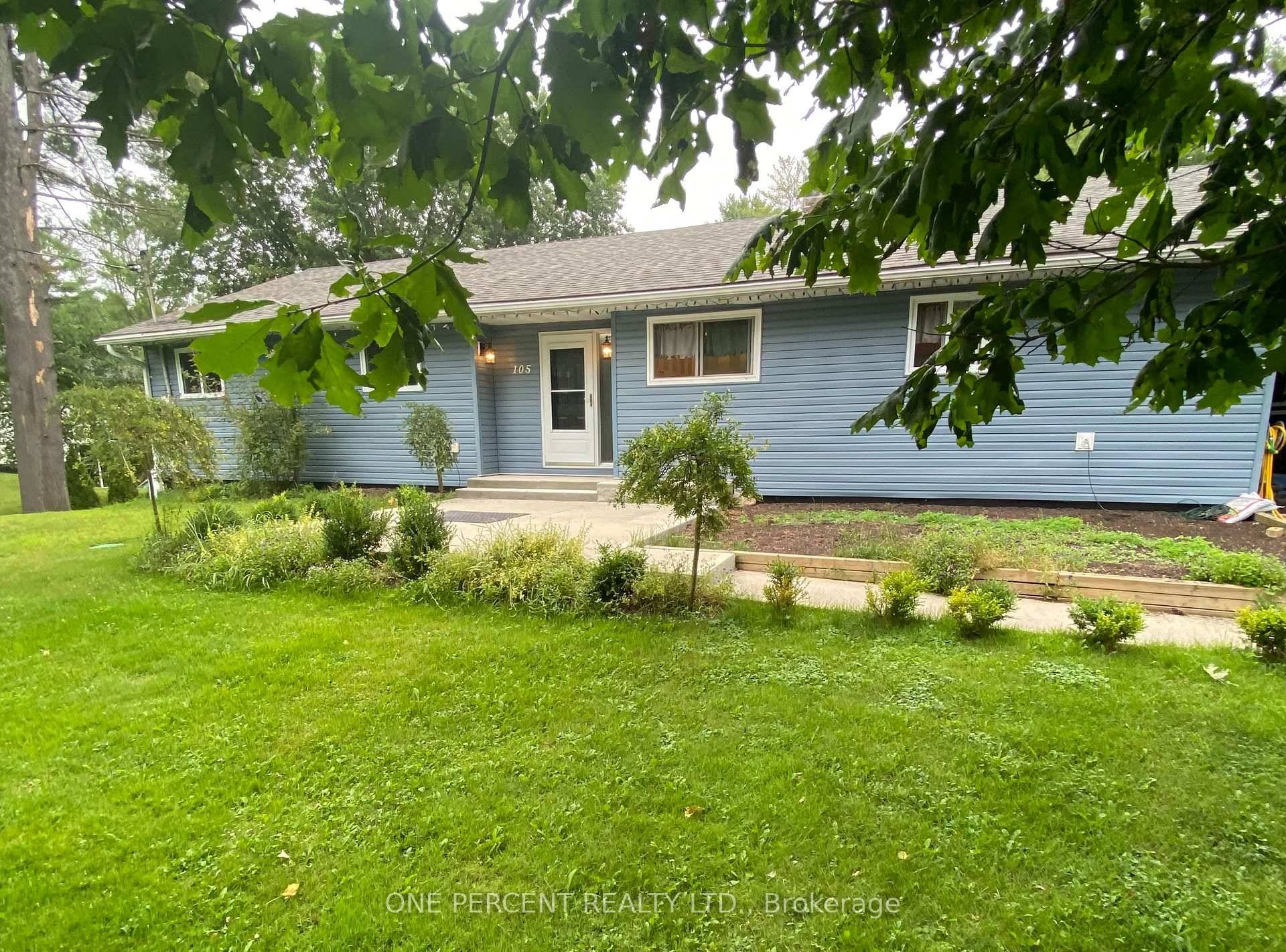 Large L shaped kitchen has an eat in Island and stools plus a wood fireplace with glass doors.