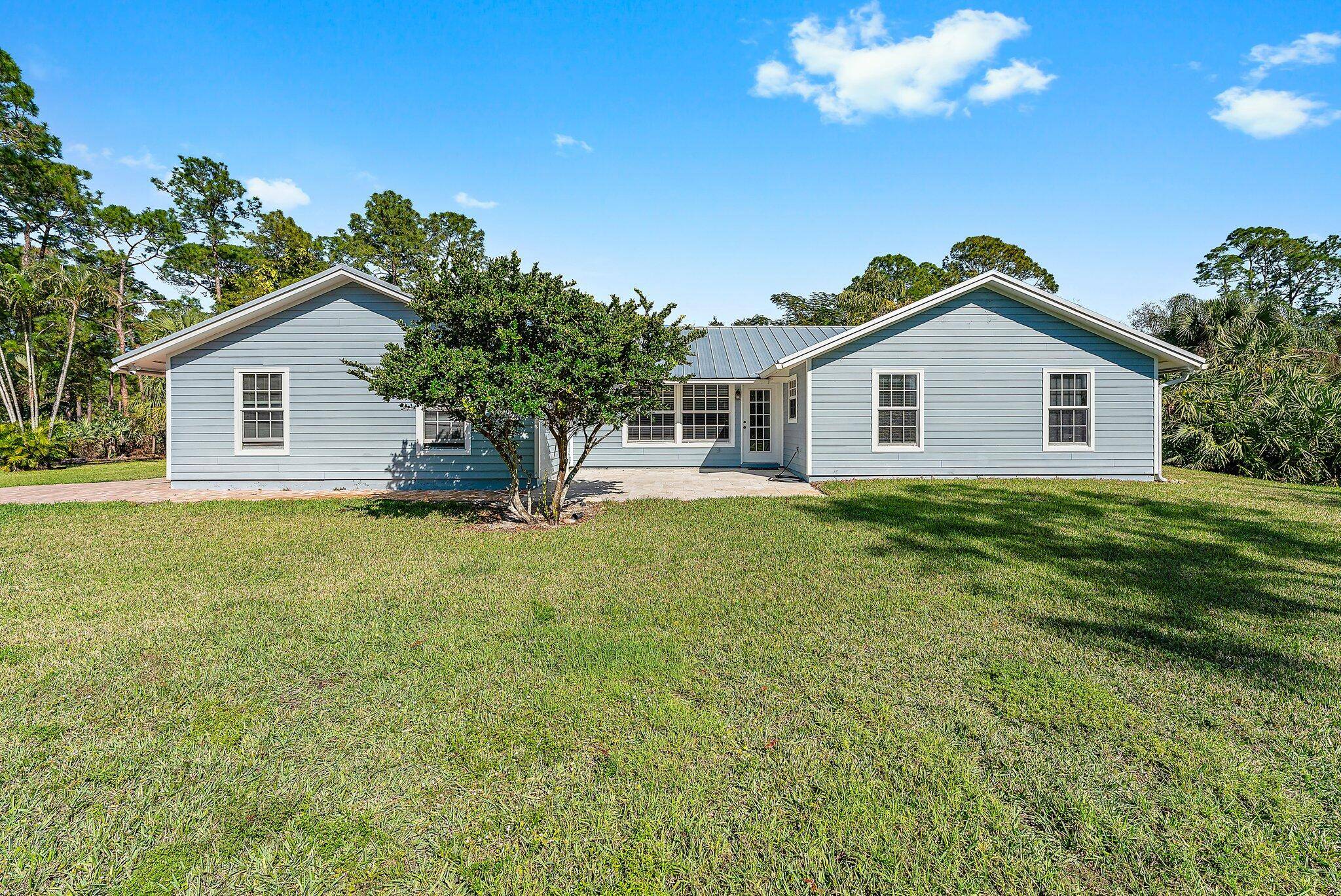 This 3 bedroom, 2. 5 bathroom Jupiter Farms home is where modern upgrades meet peaceful, private living.