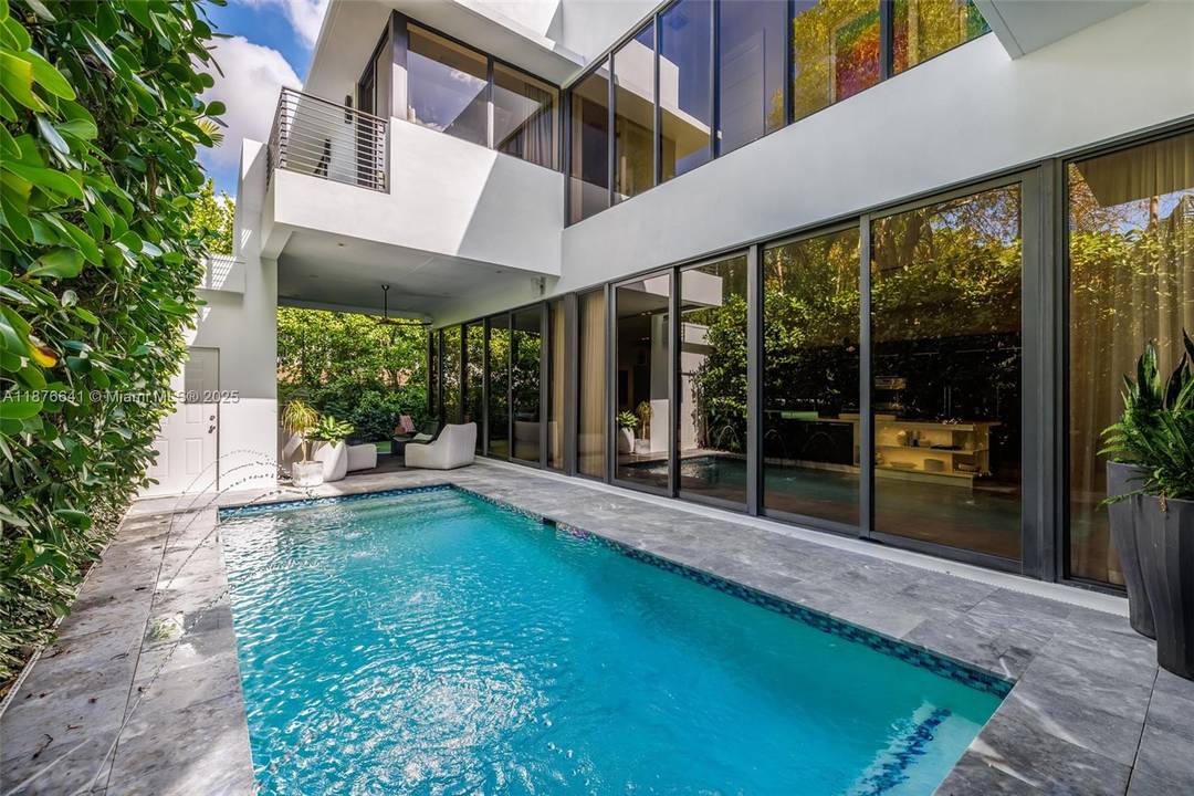 Behind a private gated entry, this tropical modern residence in North Coconut Grove blends striking design with serene surroundings.