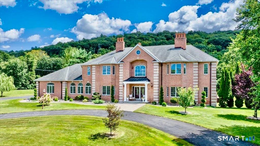 This stunning brick Colonial sits atop Hunting Ridge Drive on a sprawling two acre level lot, offering panoramic views of the Farmington Valley and breathtaking sunsets.
