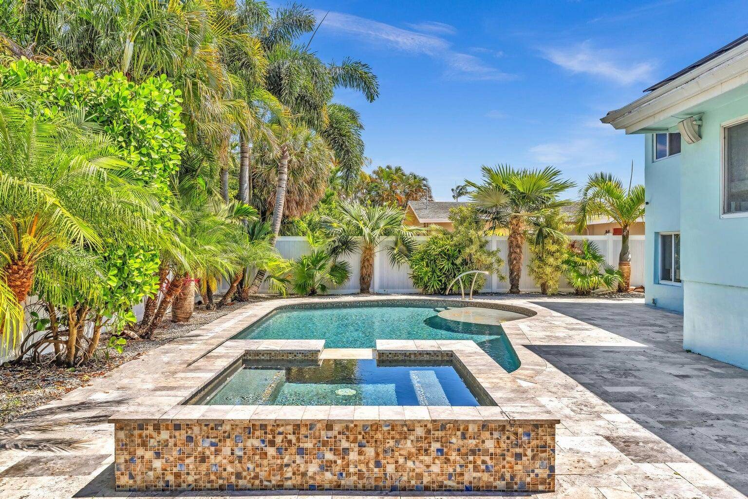 Escape to your own tropical paradise in this E Oakland Park home featuring a heated pool and spa.