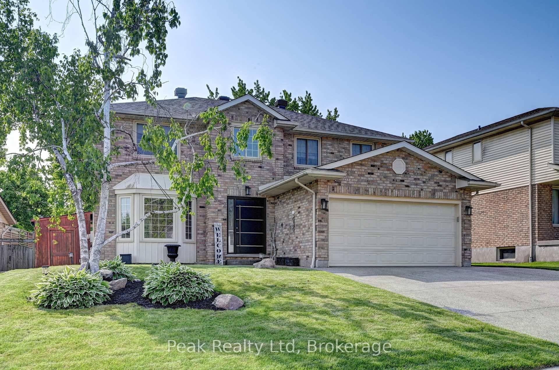 Beautifully updated home offering exceptional curb appeal with a neutral cream brick exterior, modern front door, concrete driveway, and double car garage.