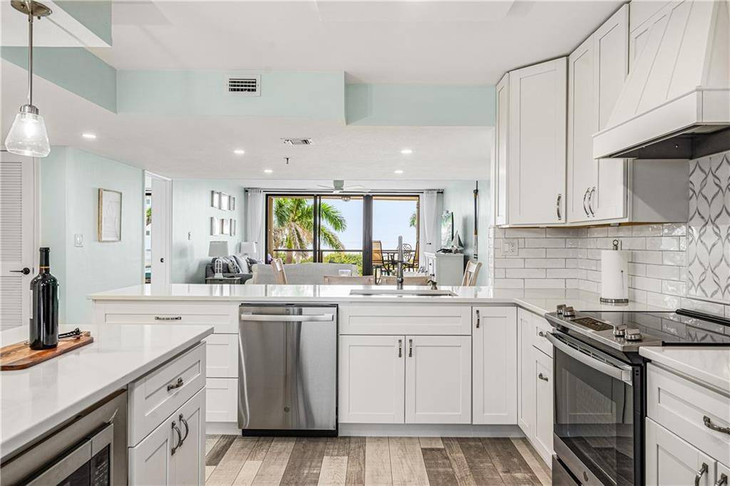 Step into coastal elegance in this turnkey condo at Avalon Beach Club, featuring 2023 luxury vinyl flooring, impact windows, accordion shutters.